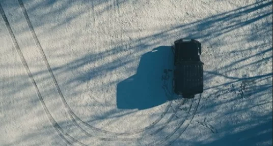 Car making tyre tracks in the snow